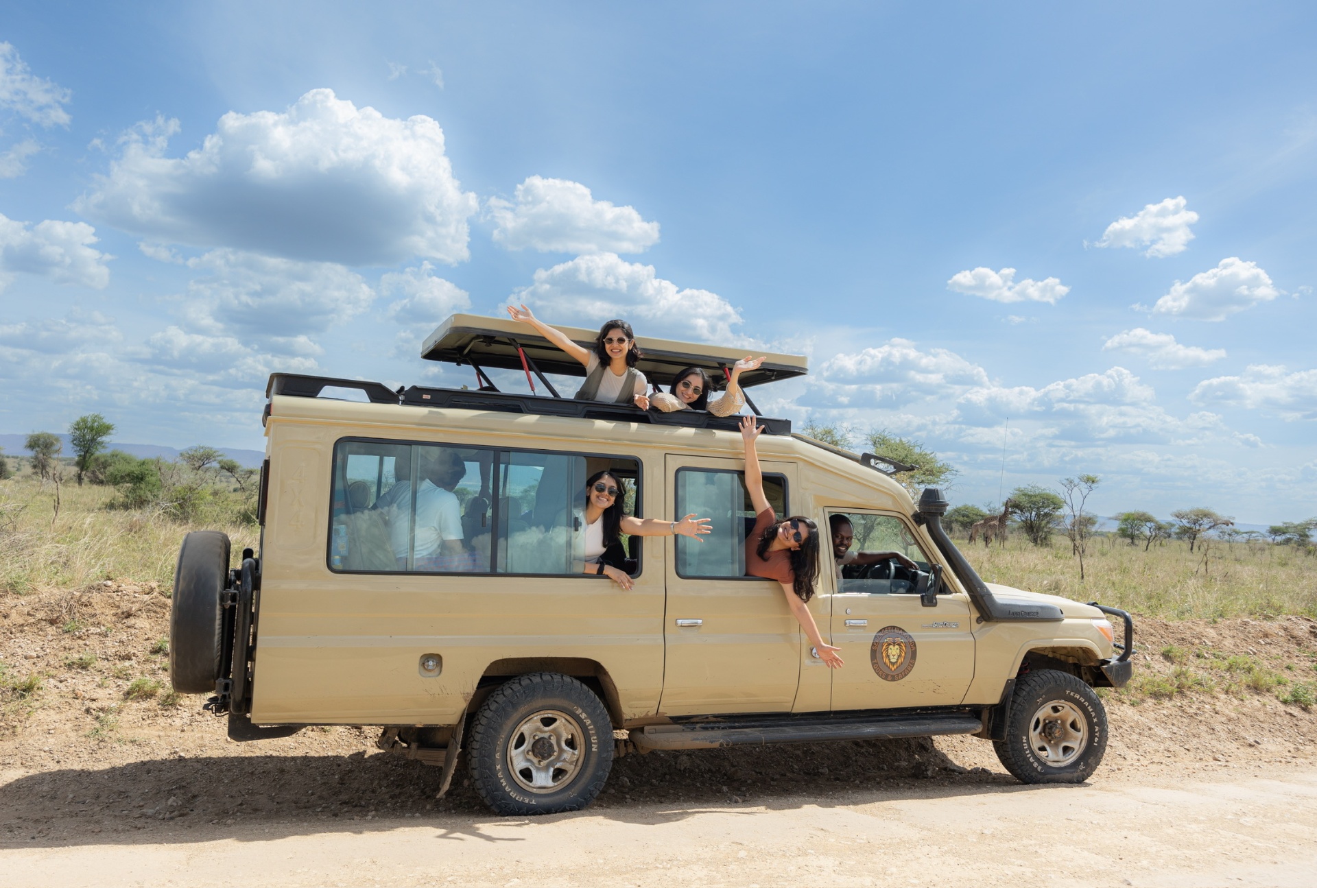 Guests laughing from the windows of a safari Land Cruiser